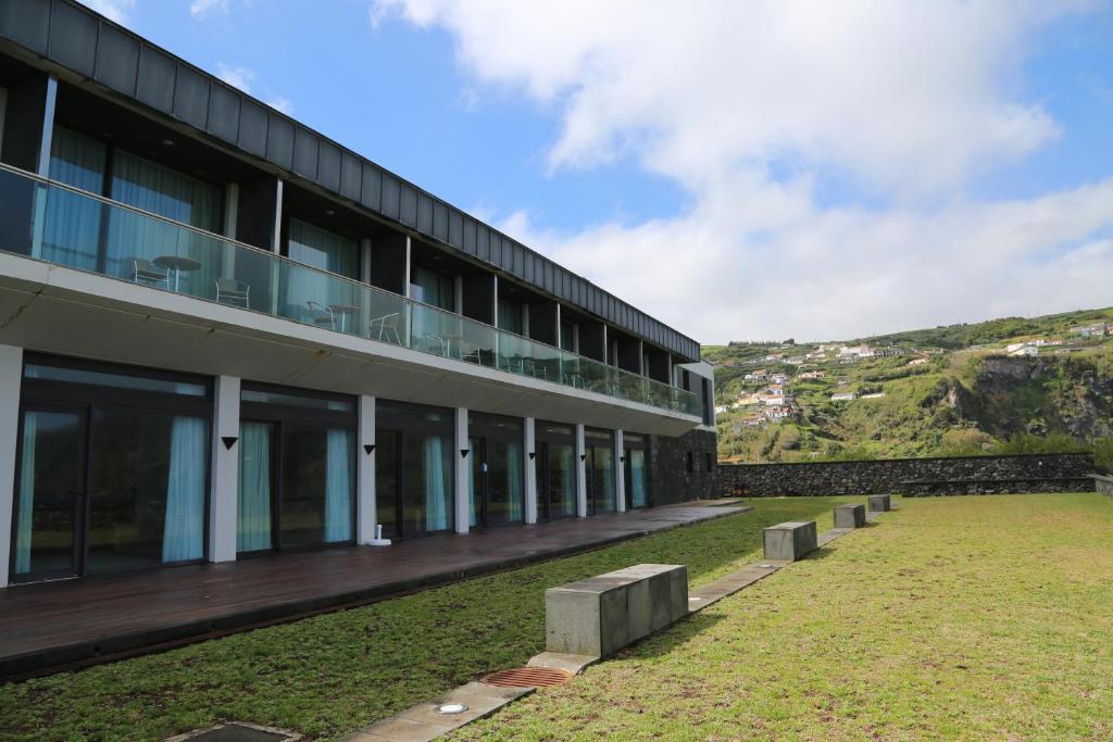 ein Gebäude mit einer Reihe von Bänken davor in der Unterkunft INATEL Flores in Santa Cruz das Flores