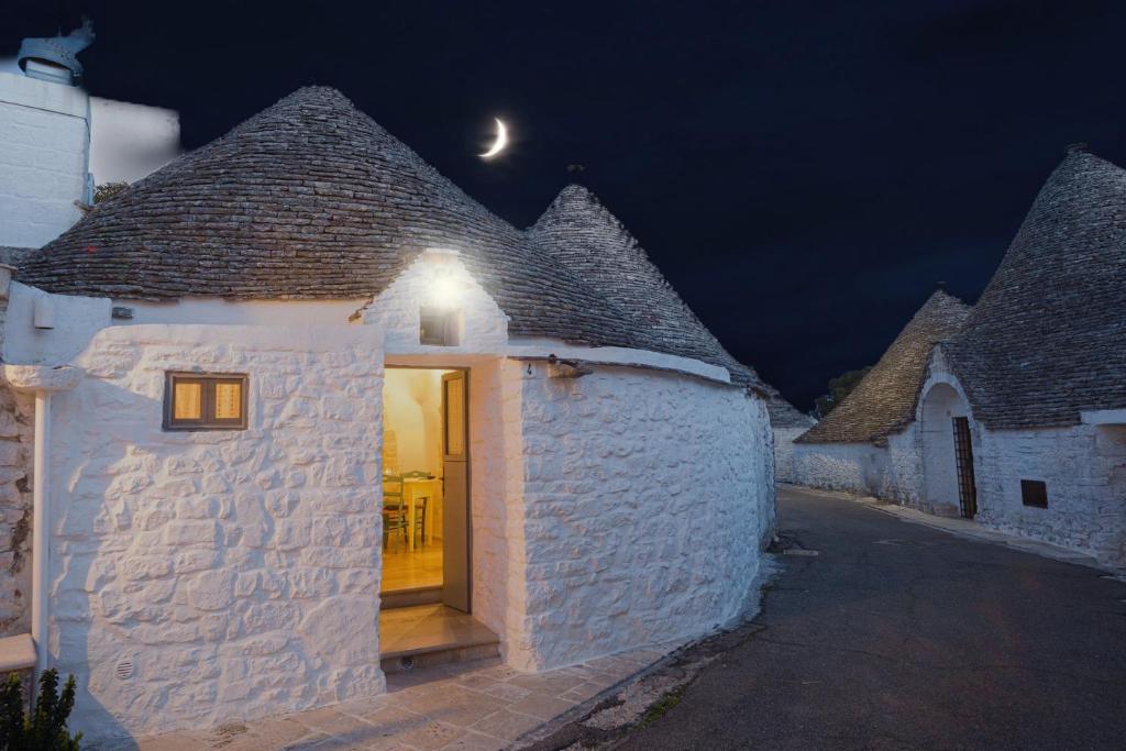 a white stone building with a door at night at Trullo Love in Alberobello