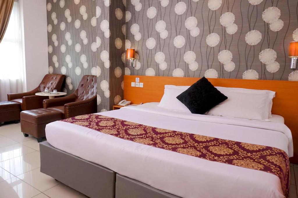 a hotel room with a bed and a chair at Marilyn Hotel Serpong in Serpong