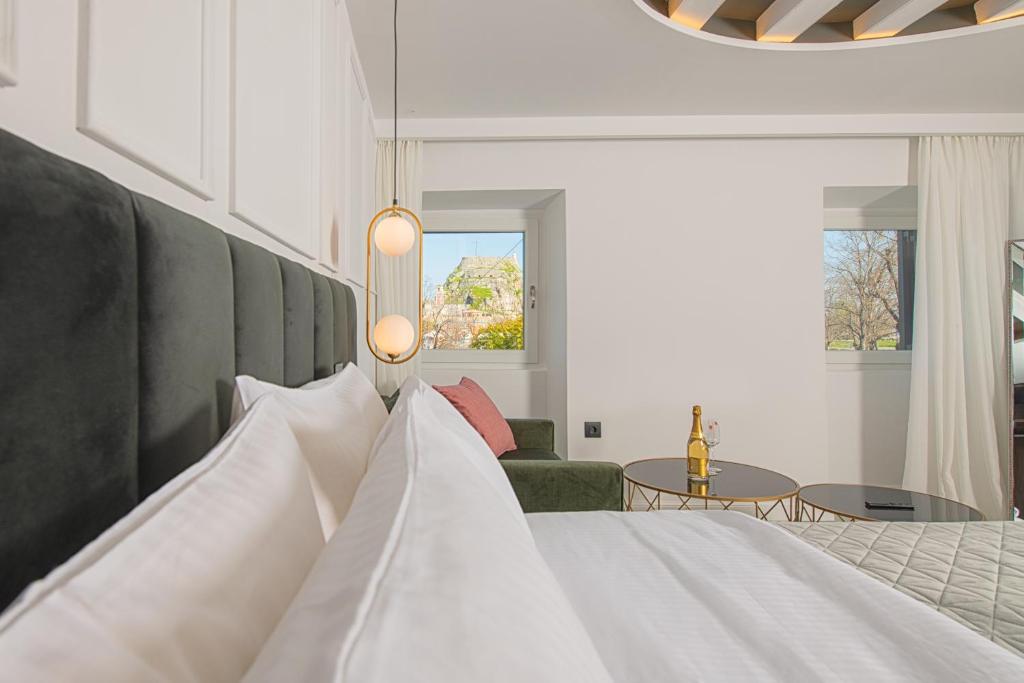 una camera con un letto bianco e un divano di Kantoni Luxury Suites a Città di Corfù