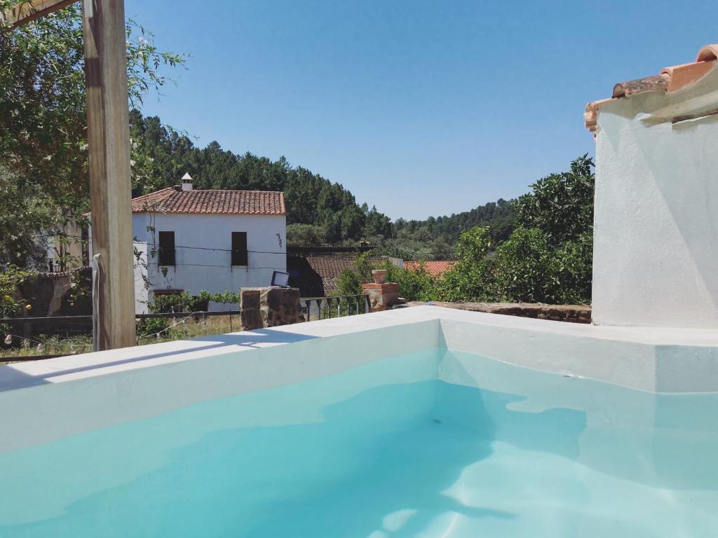 a swimming pool in a house with blue water at La Casita in Fuente del Oro