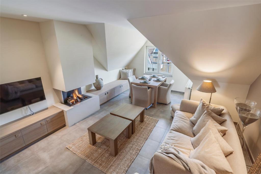 a living room with a couch and a fireplace at Duplex apartment with terrace - next to the beach in Knokke-Heist
