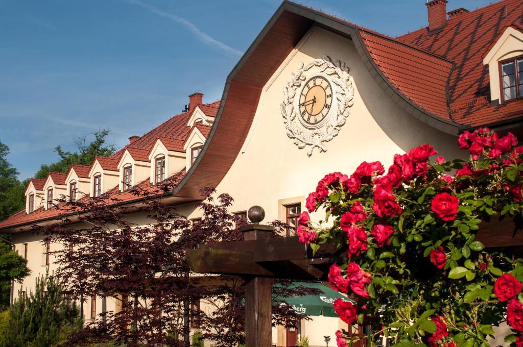 hotel facade detail with ornamental clock above entrance, vibrant red roses in foreground