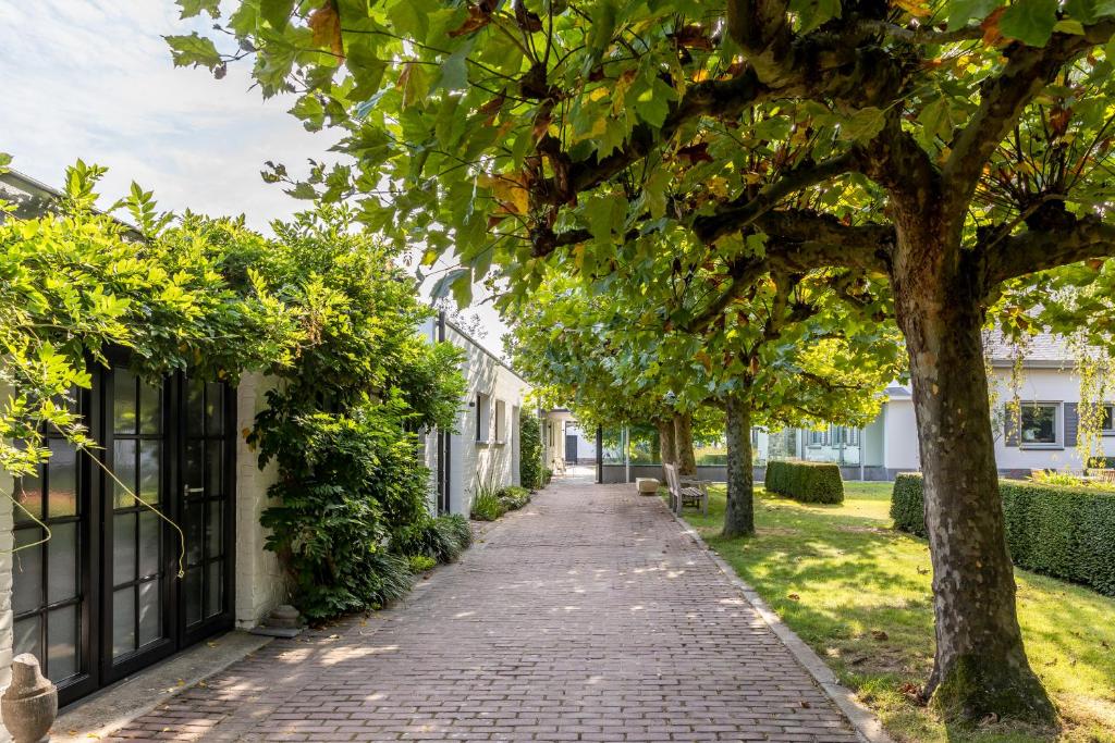 a brick sidewalk in front of a building with trees at Villa Pura Vida in Kortrijk