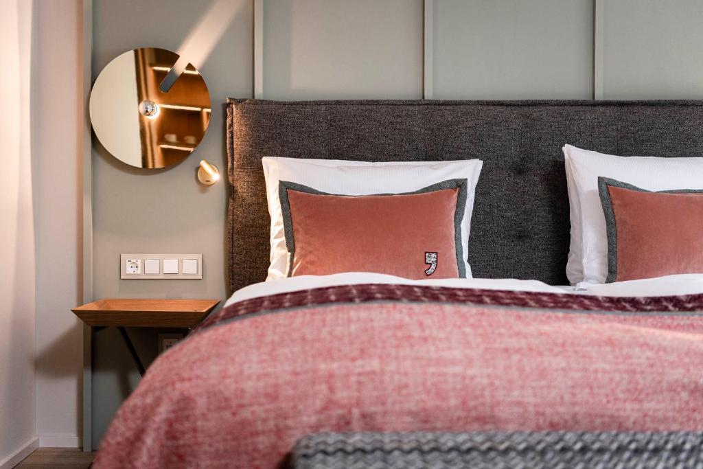 a bedroom with a bed with a red blanket and a mirror at eva,VILLAGE in Saalbach-Hinterglemm