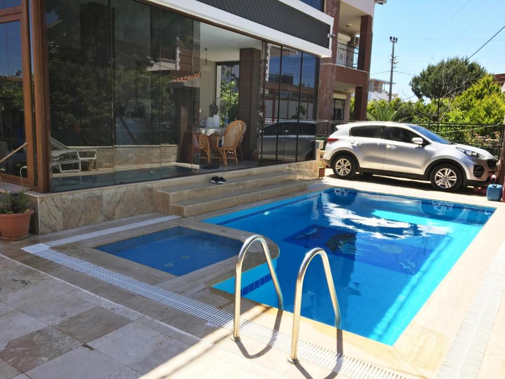 a swimming pool in front of a house at Havuz garaj deniz barbekü, 4 oda 3 banyo klimalı villa , Bahçesinde organik meyve sebze sizi bekliyoruz in Didim