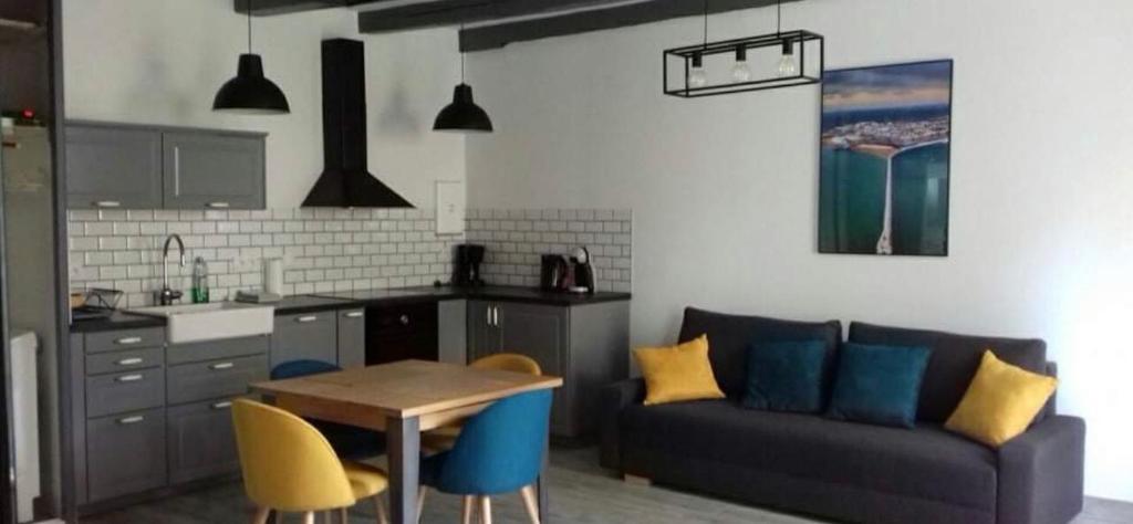 cocina y sala de estar con sofá y mesa en residence fleurie rdc, en Saint-Malo