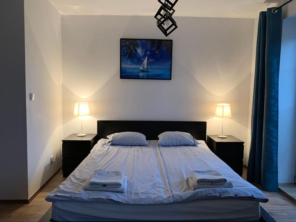 a bedroom with a large bed with two night stands at Apartamenty Żeglarskie w Vęgorii in Węgorzewo
