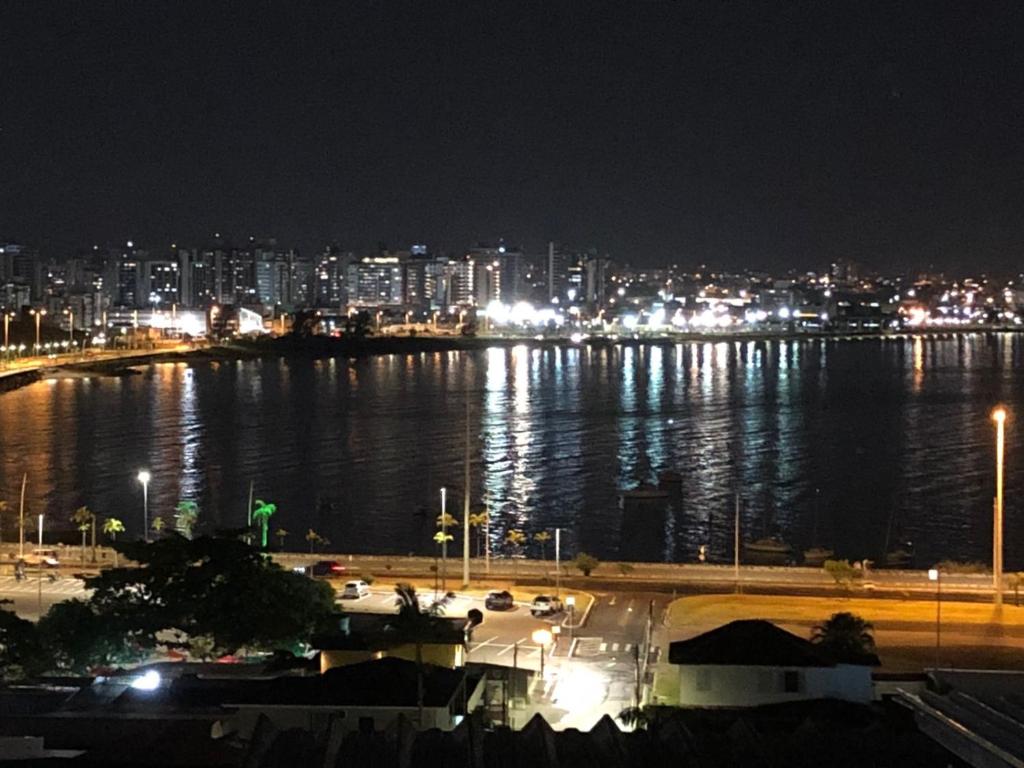 un gran cuerpo de agua con una ciudad por la noche en CASA CONCEITO - studio panoramico, suites e quartos, en São José