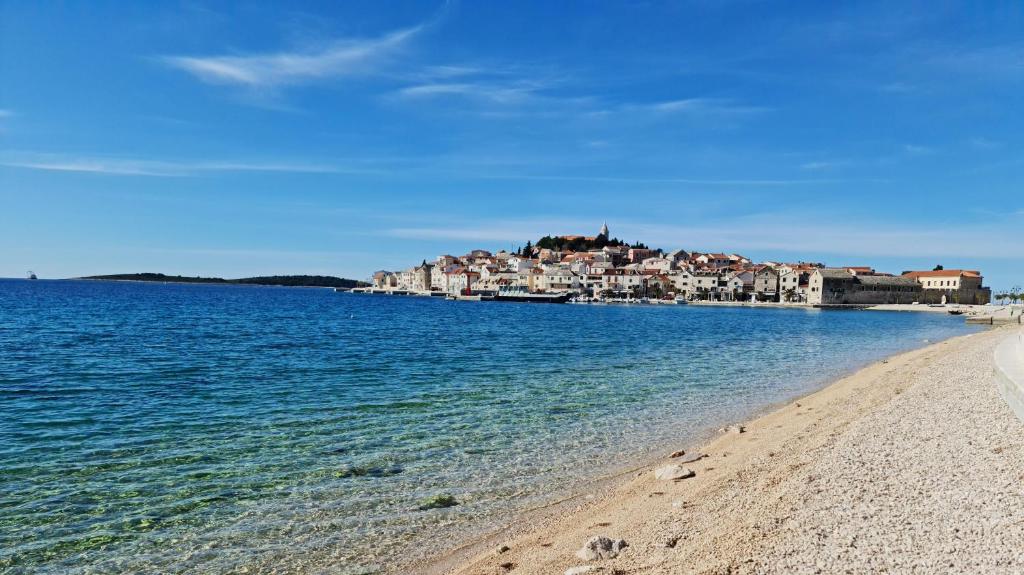 a view of a beach with a town in the background at Azalea Dalmacija Luxury Rooms and Apartments in Primošten