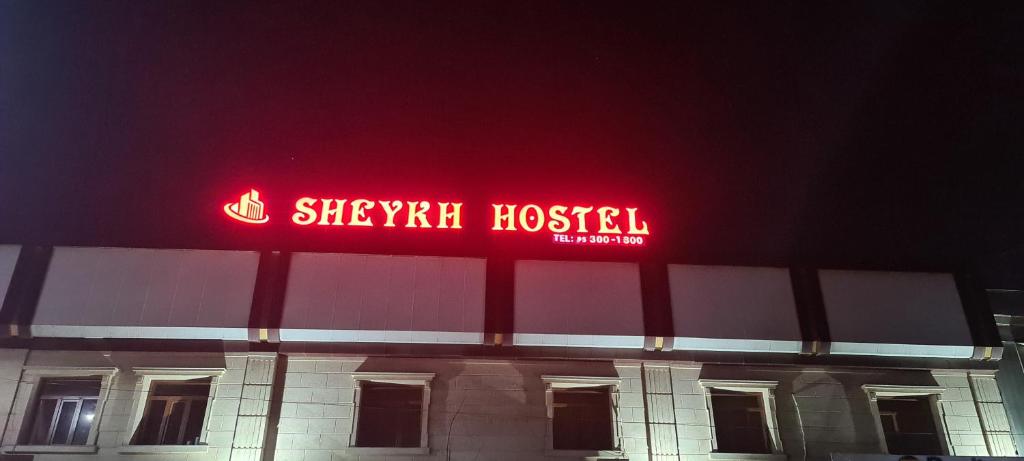 a neon sign on top of a hospital at night at Sheykh hostel in Andizhan