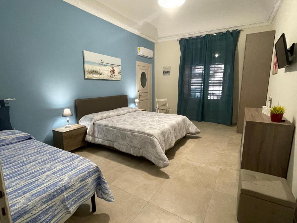 1 Schlafzimmer mit 2 Betten und blauen Wänden in der Unterkunft Porte Maqueda in Palermo