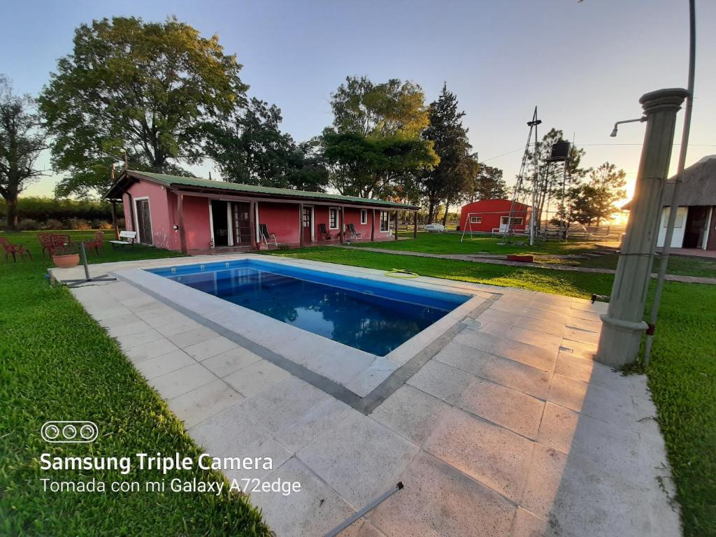 ein Schwimmbad in einem Hof neben einem Haus in der Unterkunft Quinta el quebracho in Villaguay