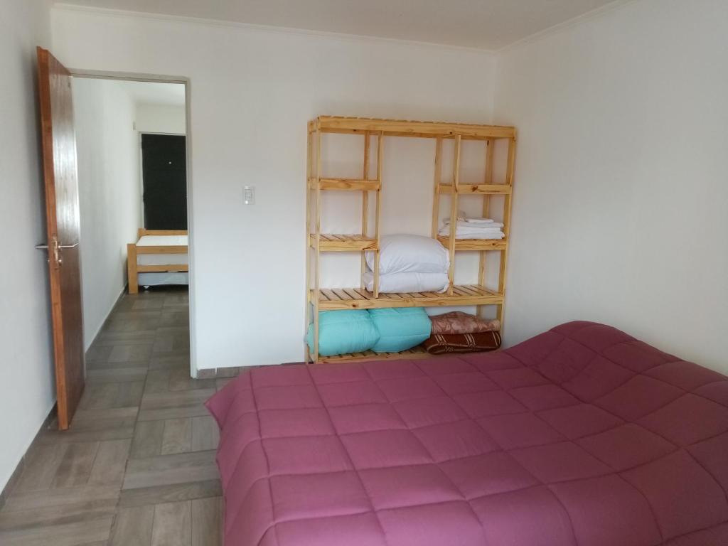 - une chambre avec un lit violet dans l'établissement Departamento Tandil, à Tandil