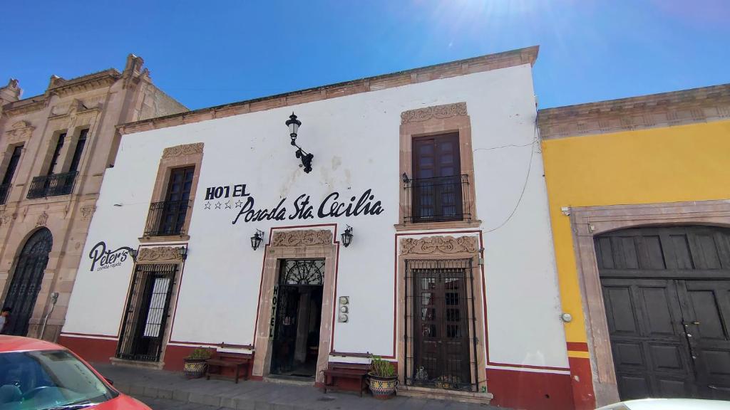 un bâtiment blanc avec un panneau sur son côté dans l'établissement OYO Posada Santa Cecilia, Jerez Zacatecas, à Jerez de García Salinas