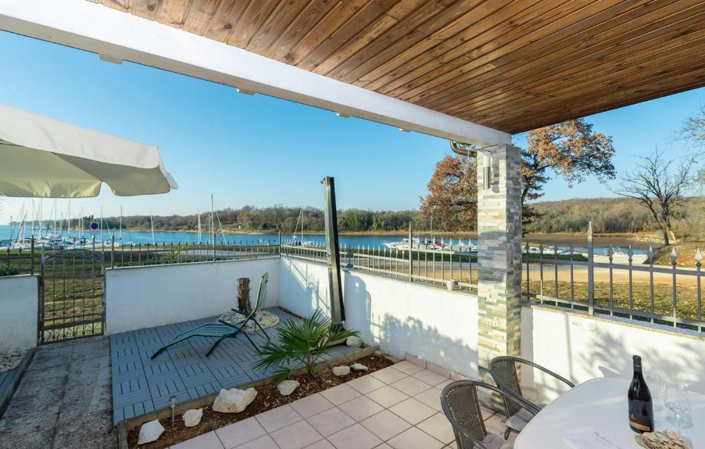 eine Terrasse mit einem Tisch und Stühlen sowie Blick auf das Wasser in der Unterkunft Cottage Sunset in Poreč