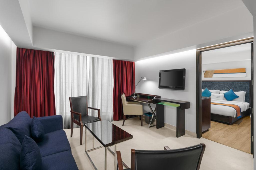 Postel nebo postele na pokoji v ubytování Golden Tulip City Centre Gurgaon
