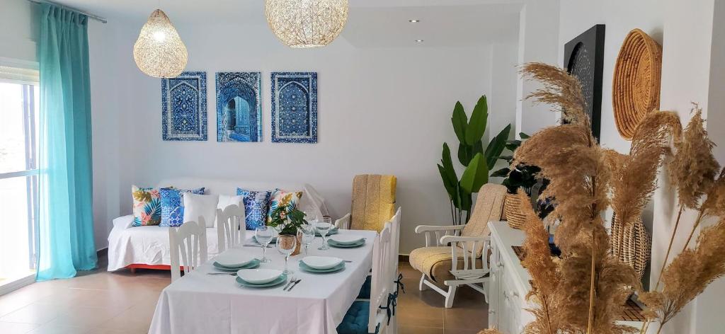 comedor con mesa blanca y sillas en Casa Rural El Duende de Tarifa, en Facinas
