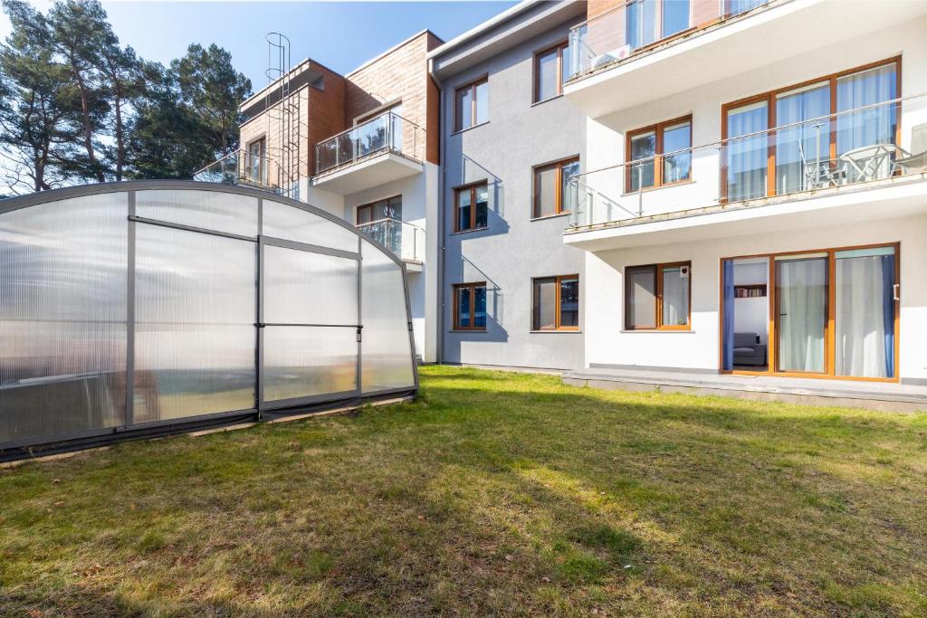 a glass extension of a house with a lawn at Villa 4 Pory Roku by Renters in Jastrzębia Góra