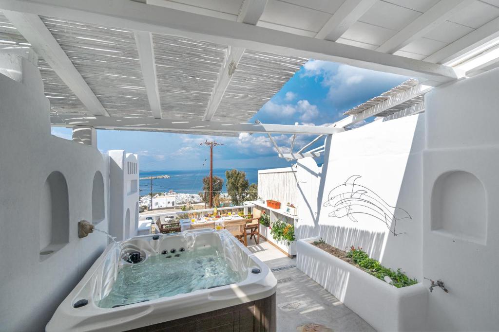 a bathroom with a bath tub on a balcony at Bella View Mykonos Town Suites in Mikonos