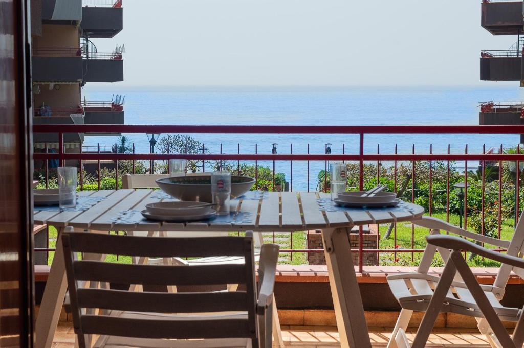 un tavolo su un balcone con vista sull'oceano di Beach House Blue Holiday a Letoianni