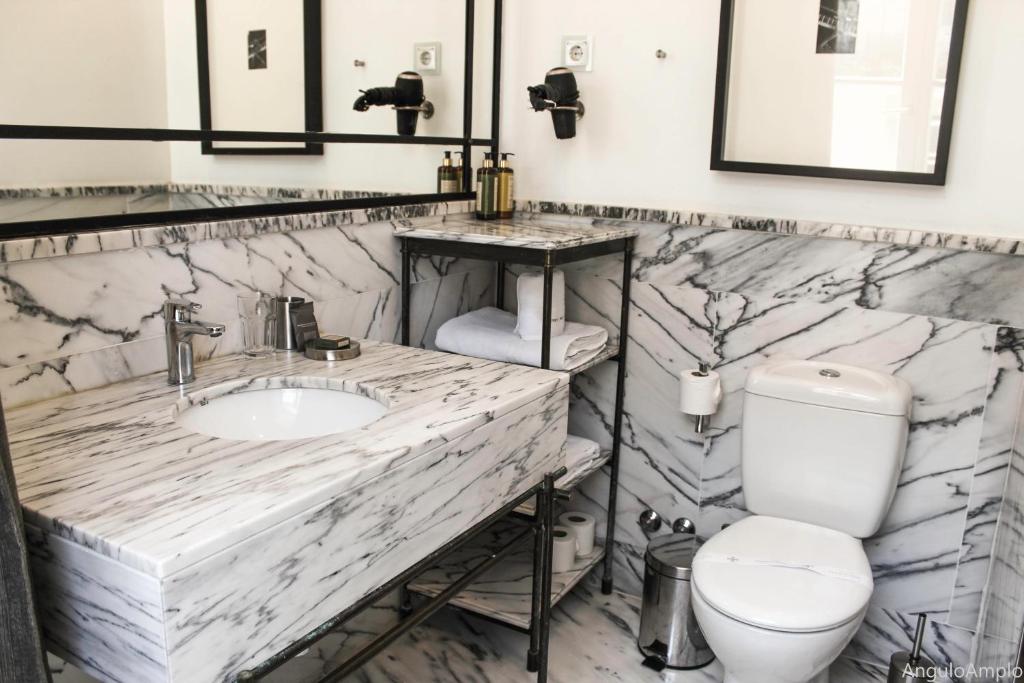 een marmeren badkamer met een toilet en een wastafel bij Browns Boutique Hotel in Lissabon
