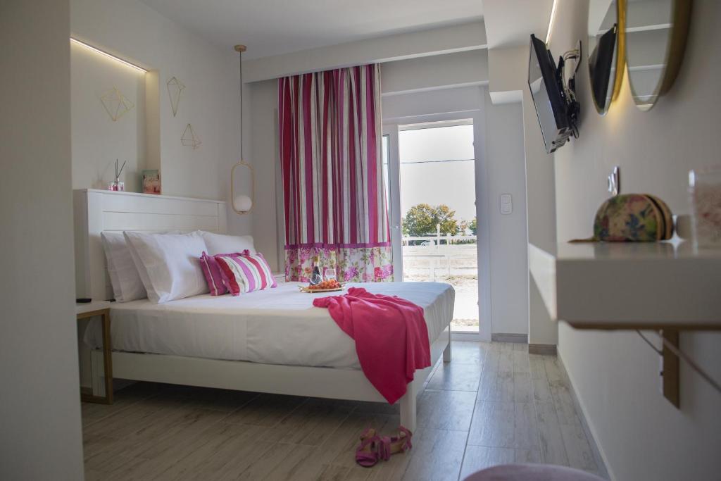 um quarto com uma cama branca e uma janela em Anastasia Mare Luxury em Stavros