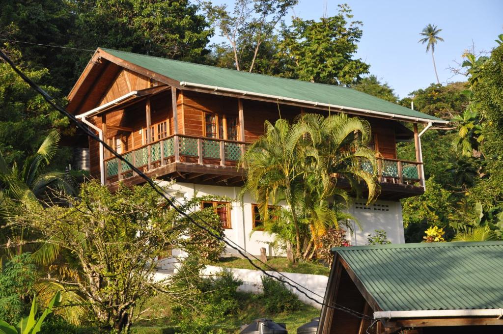 a wooden house with a green roof at Castara Villas in Castara