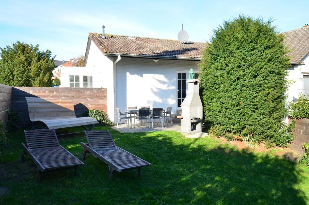 a yard with two chairs and a bench and a house at Haus Frauken in Grömitz