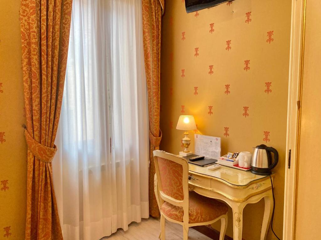 a room with a desk with a lamp and a window at Hotel San Gallo in Venice