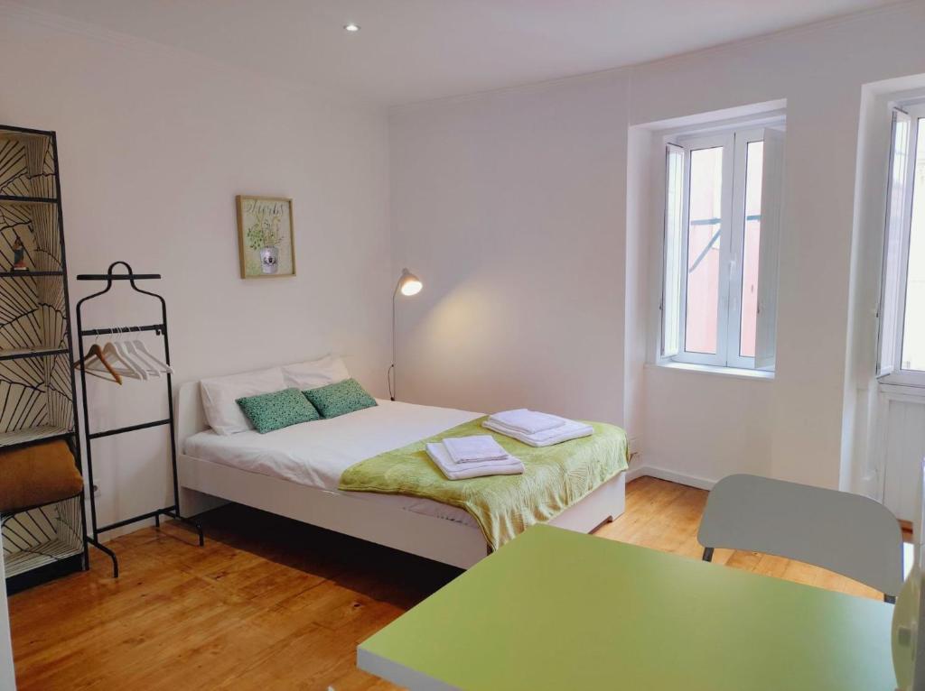 リスボンにあるEco Green Studio Apartmentの小さなベッドルーム(ベッド1台、テーブル付)