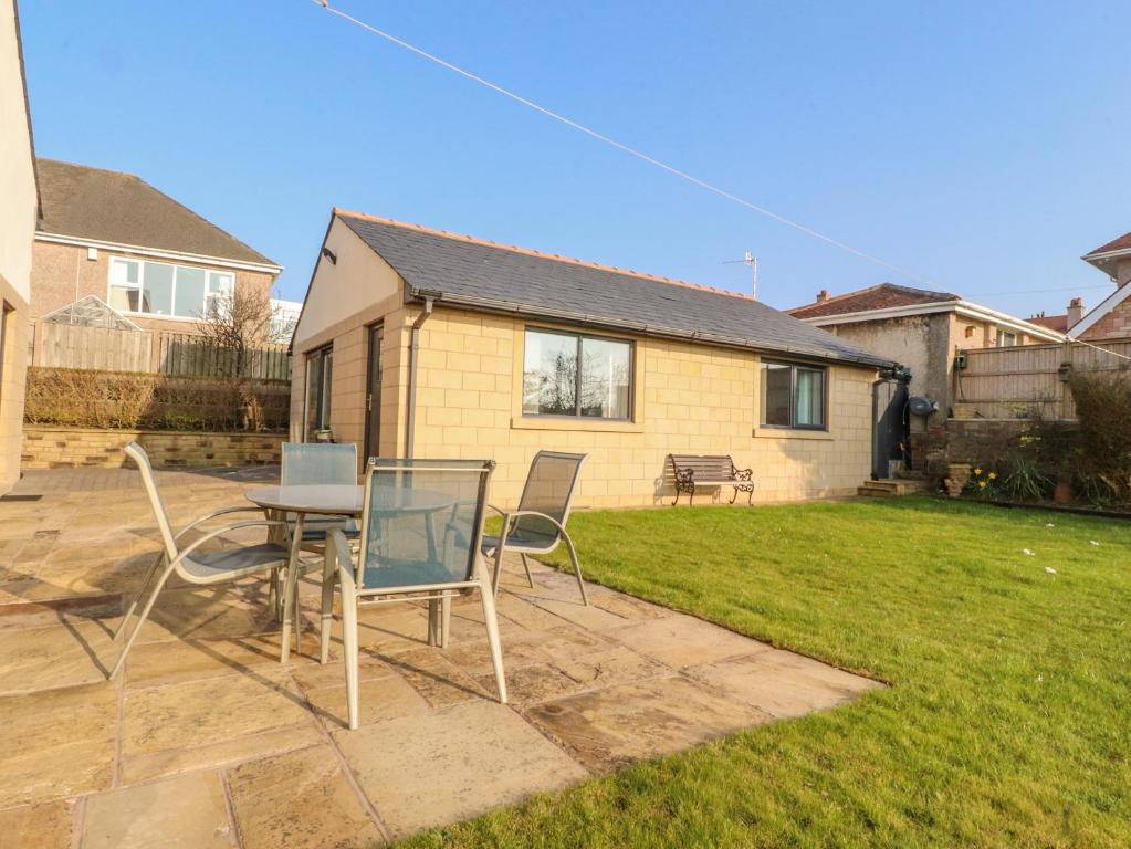 a patio with chairs and a table and a house at 2 Bedroom Annexe in Morecambe