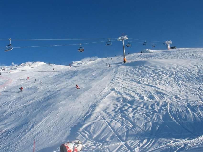 un gruppo di persone che scia lungo una pista da sci coperta dalla neve di Koča pri Binci a Cerklje na Gorenjskem