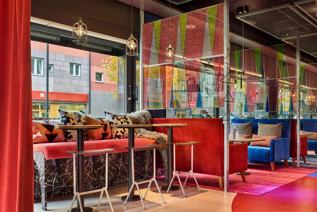 a restaurant with red and blue chairs and tables at Generator Stockholm in Stockholm