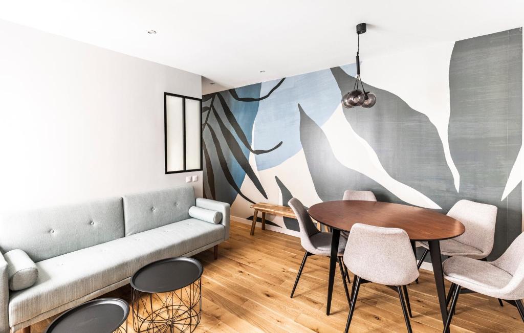 un salon avec un canapé, une table et des chaises dans l'établissement 127 St Dom - Emplacement parfait - Paris 7ème, à Paris