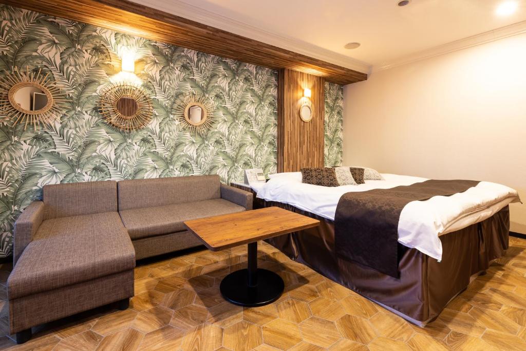 een hotelkamer met een bed en een bank bij Mie Loco Garden (Adult Only) in Komono