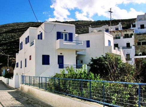Mérikhas的住宿－Driopida 5 Irida，白色的建筑,设有蓝色的窗户和栅栏