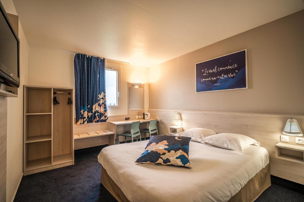 Pokój hotelowy z łóżkiem i biurkiem w obiekcie ACE Hôtel Bordeaux Carbon Blanc w mieście Carbon-Blanc