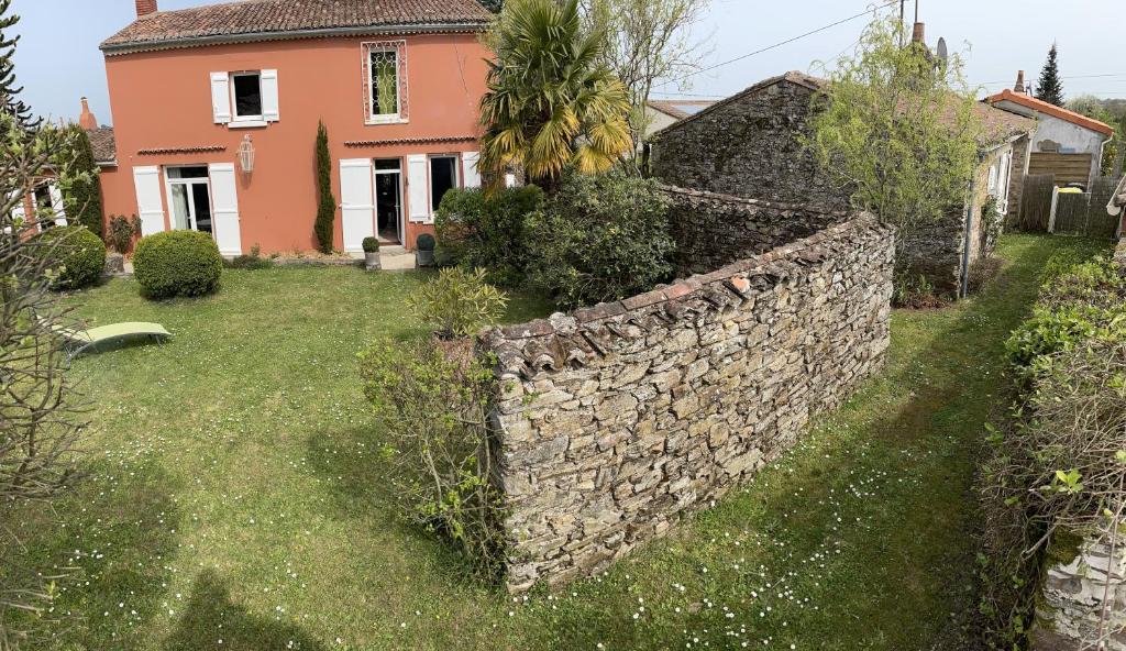un mur en pierre devant une maison dans l'établissement La Charaudière, à Champtoceaux
