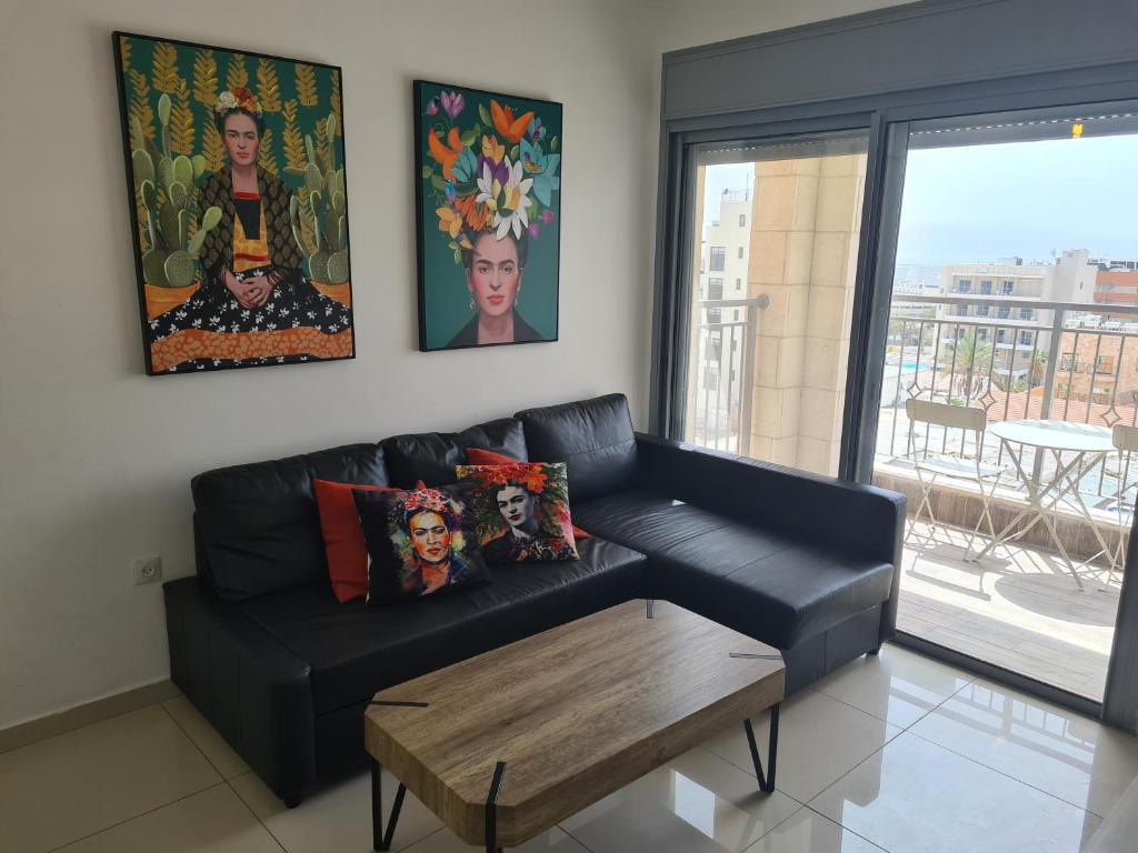 a living room with a black leather couch and a table at Red Mountains apartments in Eilat