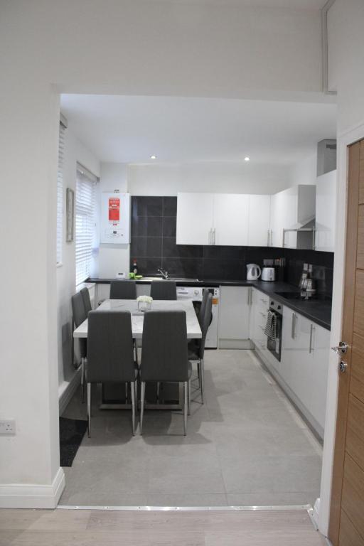 a kitchen and dining room with a table and chairs at Beautiful, Spacious, Old Trafford home in Manchester