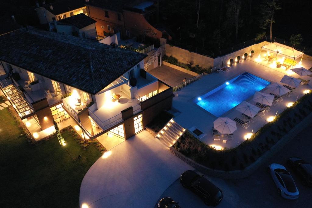 an aerial view of a house with a swimming pool at night at Villa Francesca Relais in Gradara