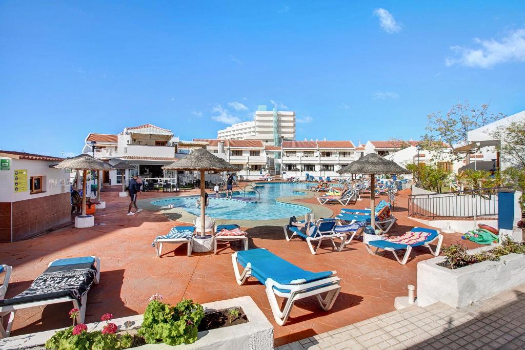 una piscina con sillas y sombrillas en un resort en Garden City, en Costa de Adeje