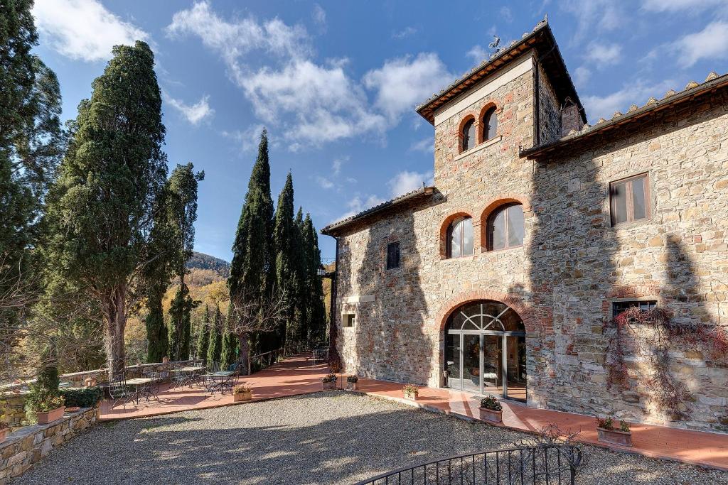 un grande edificio in pietra con alberi sullo sfondo di Terre di Baccio a Greve in Chianti