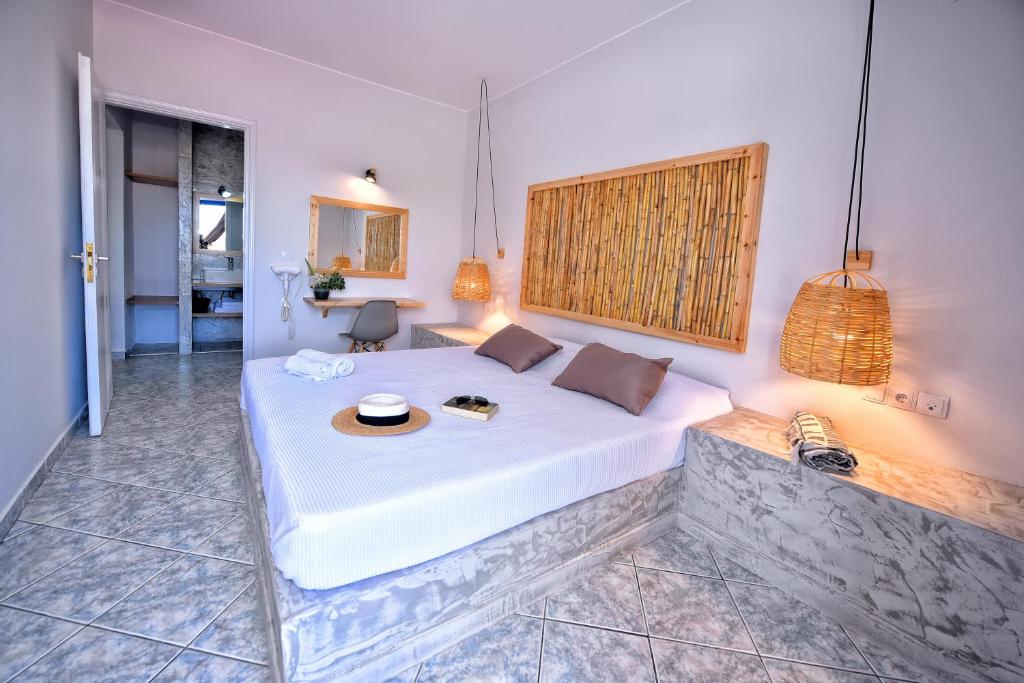 een slaapkamer met een groot wit bed in een kamer bij Mikes on the beach in Chersonissos