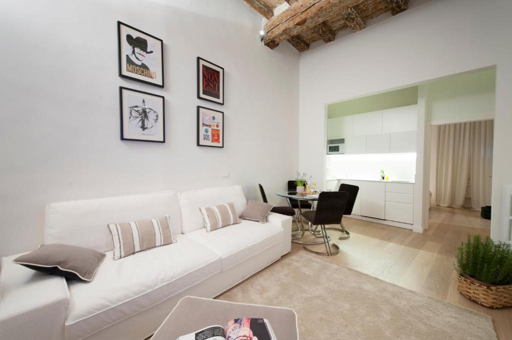 un soggiorno bianco con divano bianco e tavolo di Apartments Florence - Federighi a Firenze