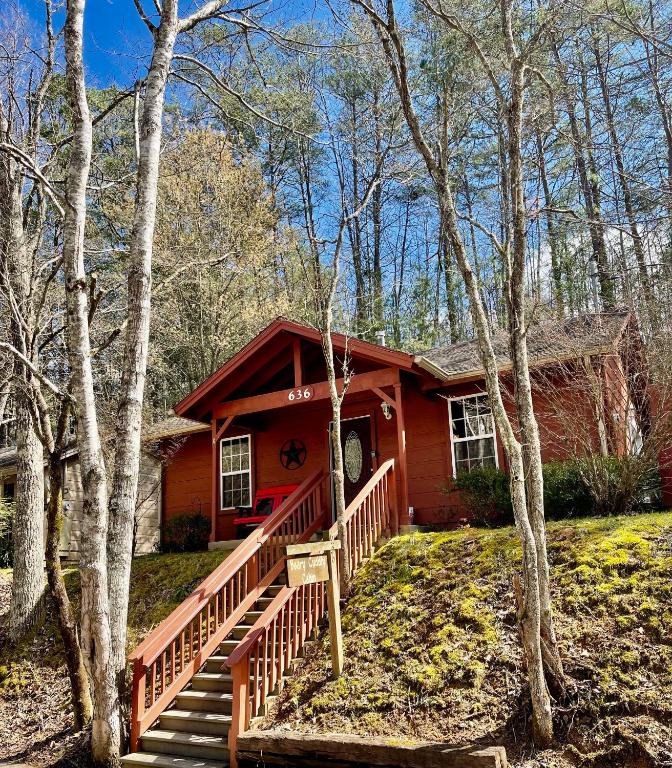 a small red house with a staircase in the woods at Beary Cuddly Hottub 10 Mins Downtown Gatlinburg National Park in Gatlinburg