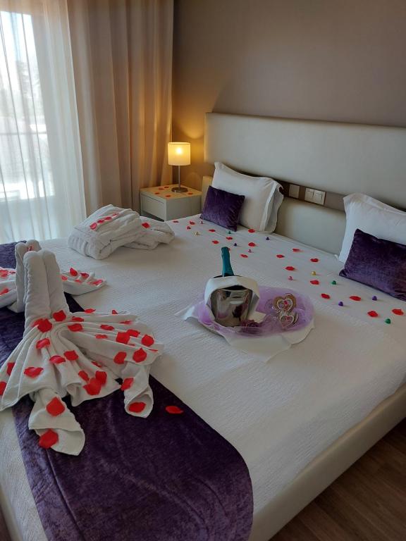 a bedroom with a large white bed with decorations on it at Hotel Monte Lírio in Espinho