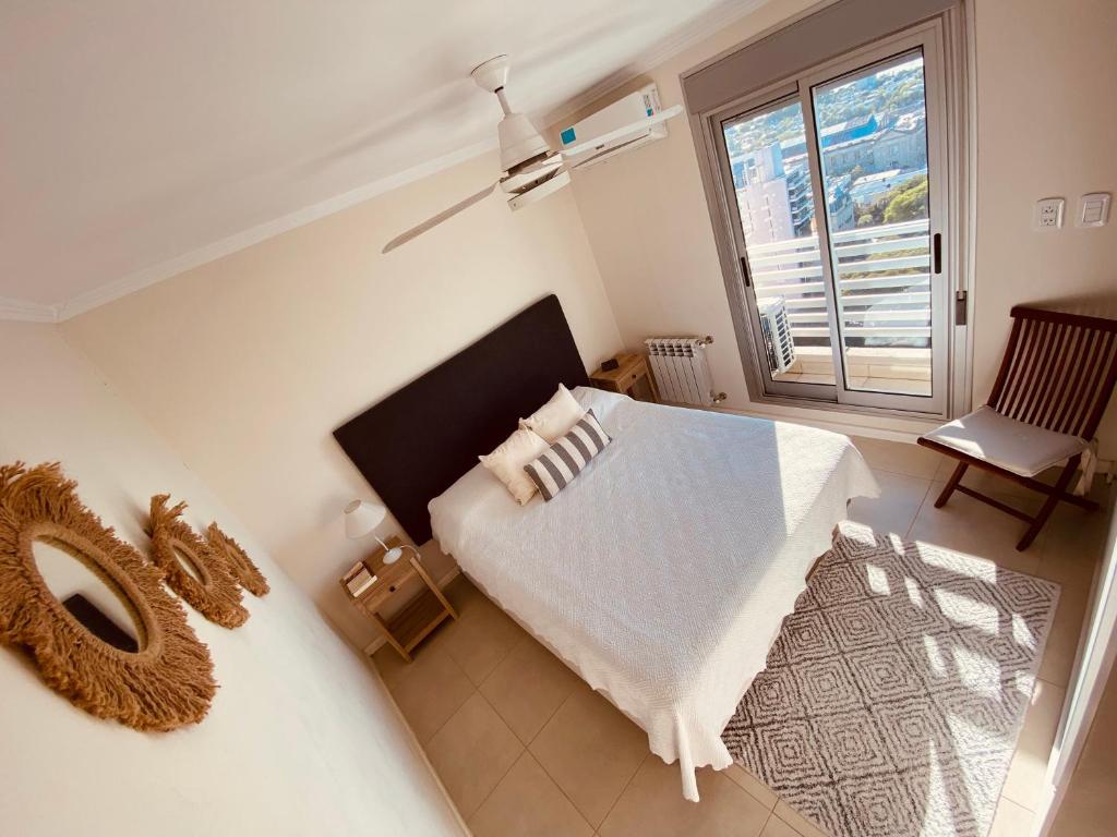 a bedroom with a white bed and a window at Exclusivo Departamento en piso 20 sobre Bv Gálvez, cochera y piscina in Santa Fe