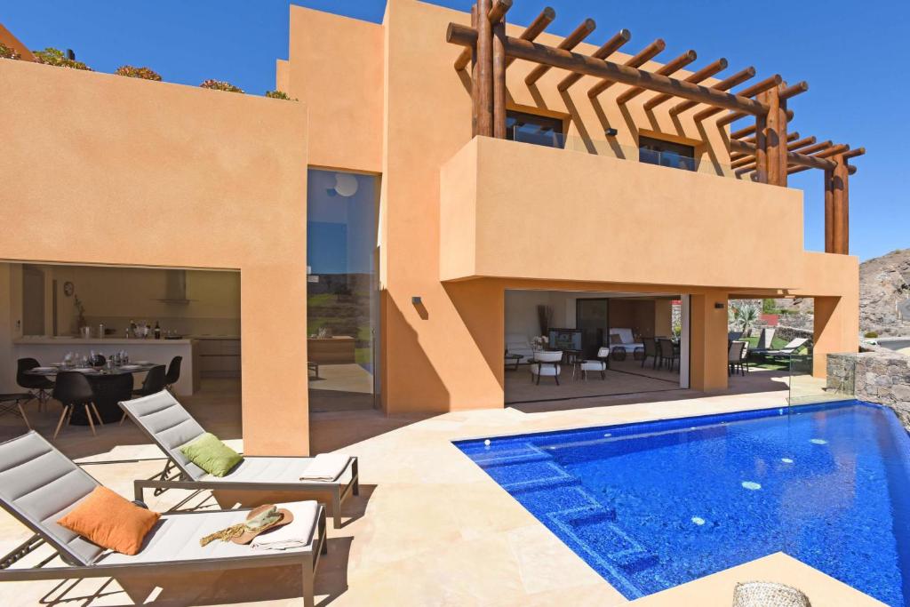 a villa with a swimming pool and a house at Salobre Villa Cardón in Maspalomas